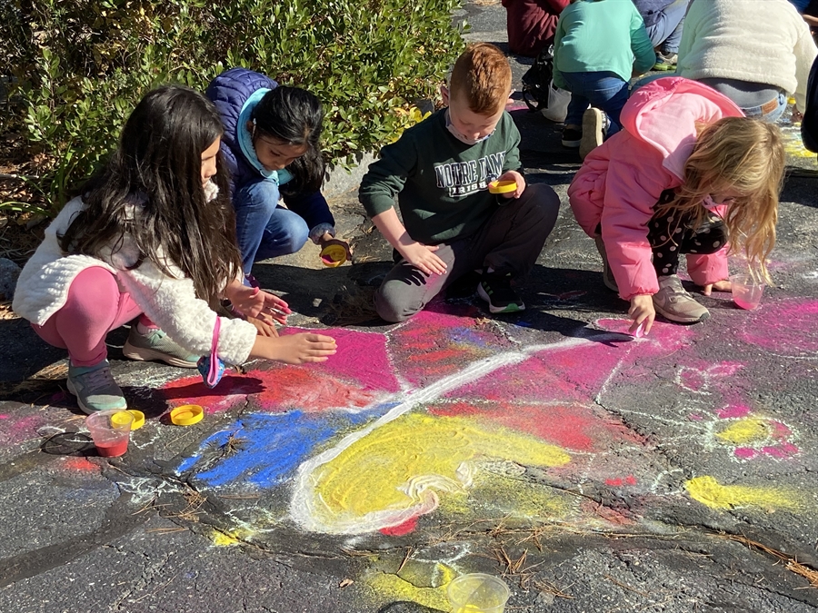 Students decorating the sidewalk with rangoli designs during Diwali
