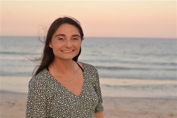 Ms. Spagnuolo on the beach with a sunset