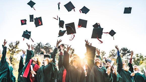 Graduates throwing caps
