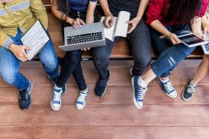 people on a bench holding a laptop