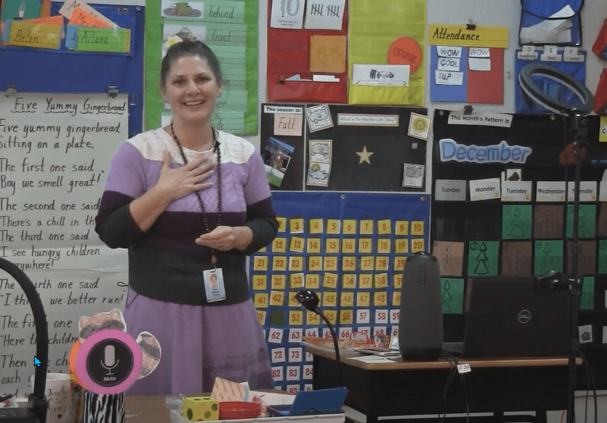 a woman in a classroom standing in front of a computer and OWL Camera