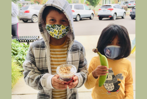 two students holding meals from Bethel Schools