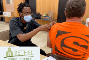 Man administering vaccination at Cascade middle school