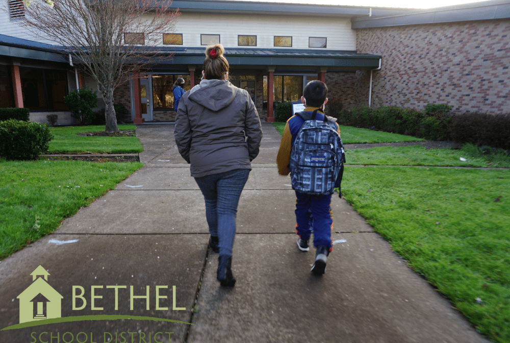 parent and student walk toward school