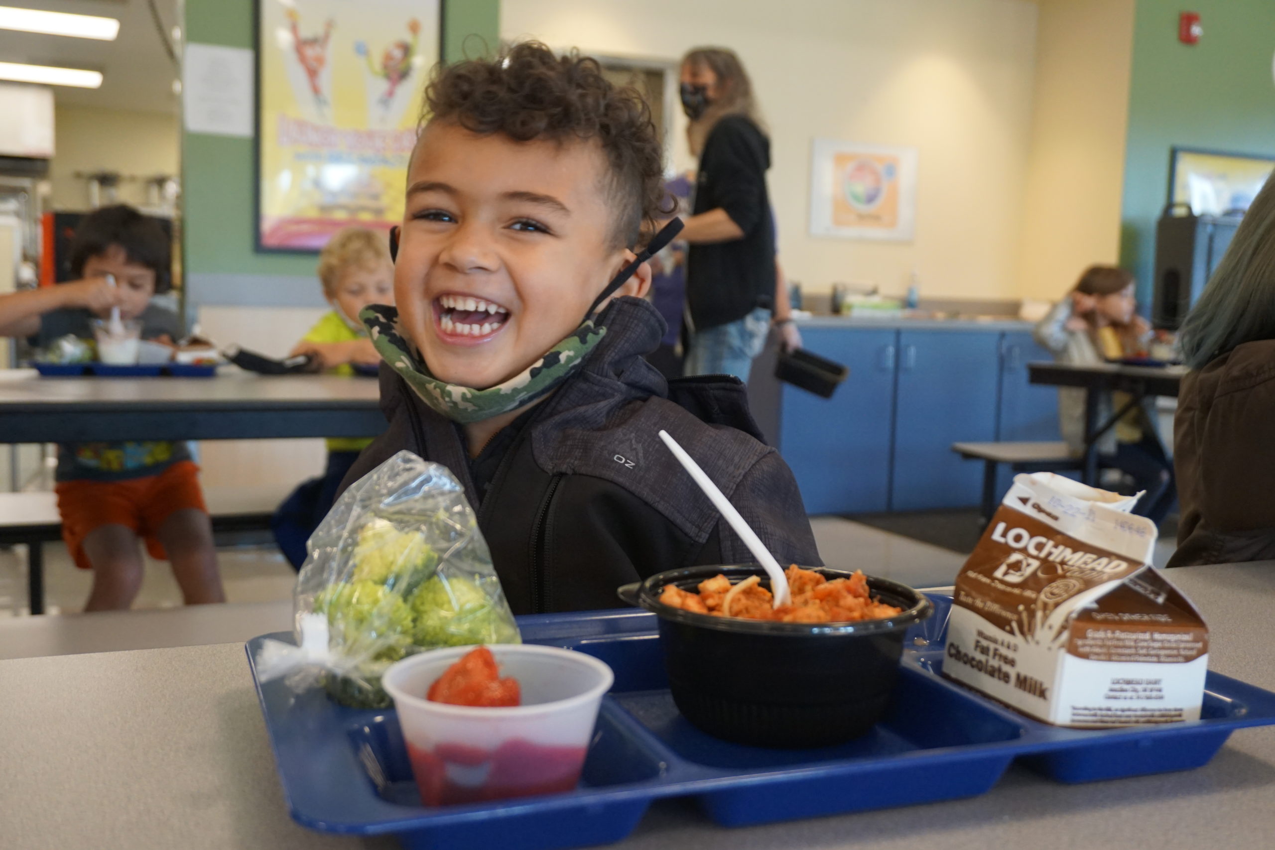 Smiling child eating lunch in the classroom