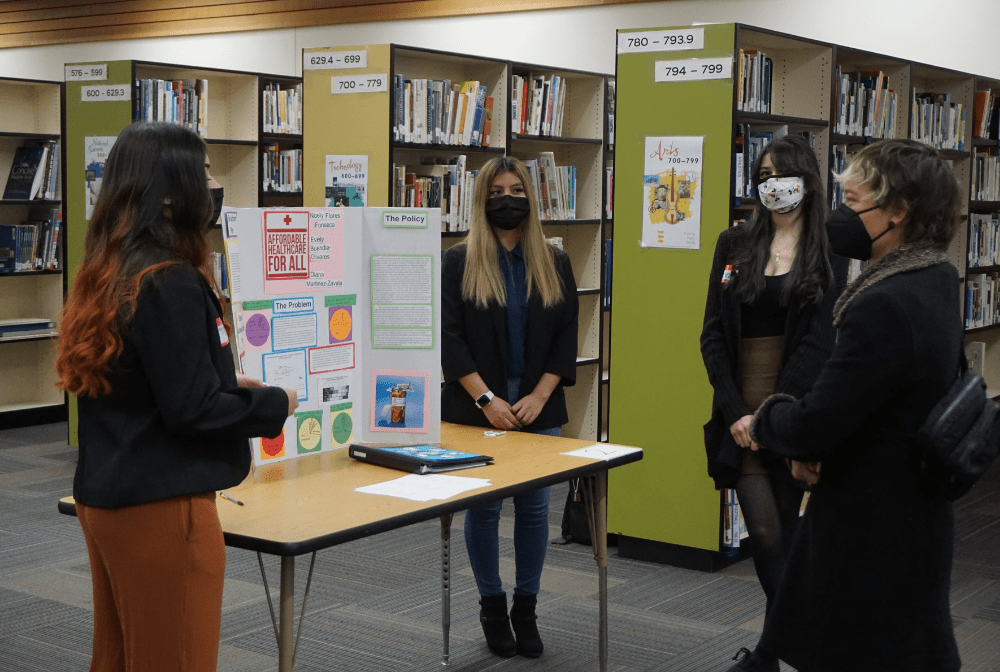 WHS students stand in the WHS media center to give a presentation