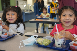 2 girls with lunch trays in front of them