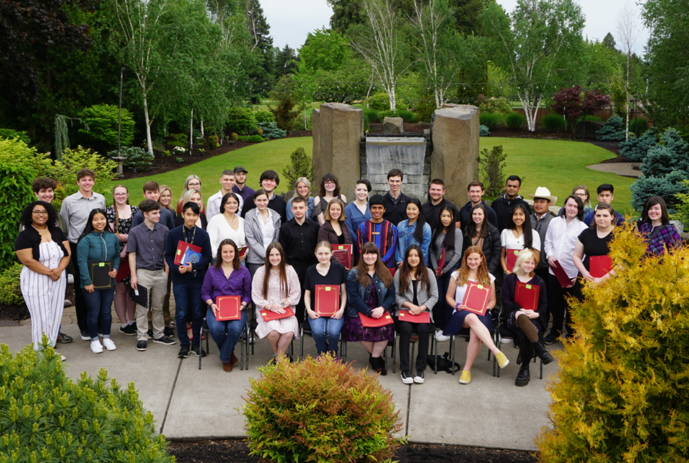 a group of students holding red folders