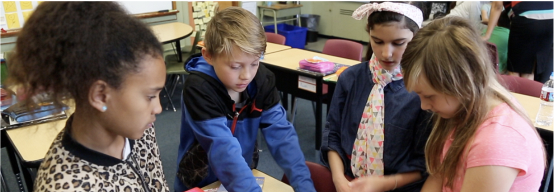 Four students around a desk