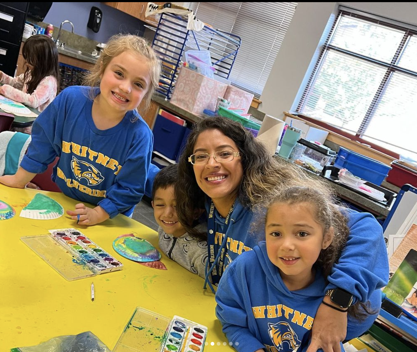 Three students with teacher over desk Three students with teacher over desk