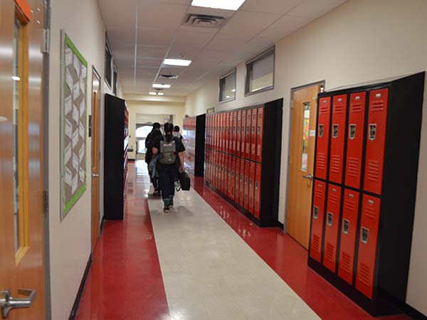 Students walk to lockers in hallway at middle school