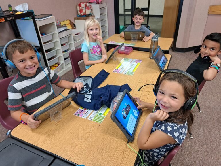 elementary students at their desks learning with ipads