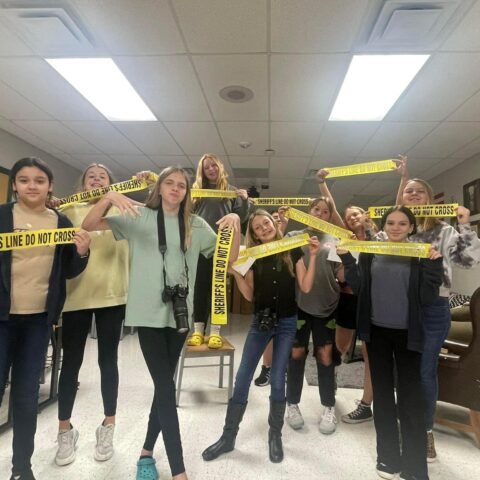 photo of the criminal justice students holding up crime scene tape