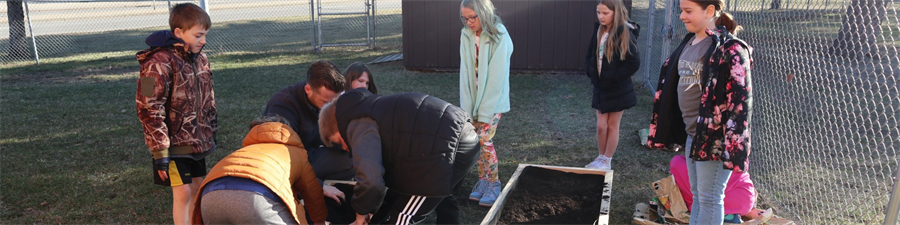 Riverside students prepare the garden beds for spring plants.