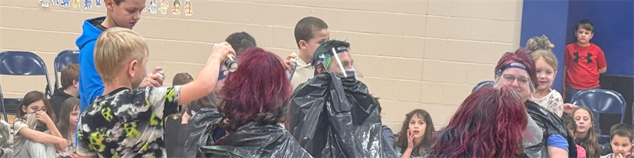 As a reward for their exceptional efforts in the Glow Run fundraiser, the top-performing students were given the opportunity to spray paint a staff member's hair.