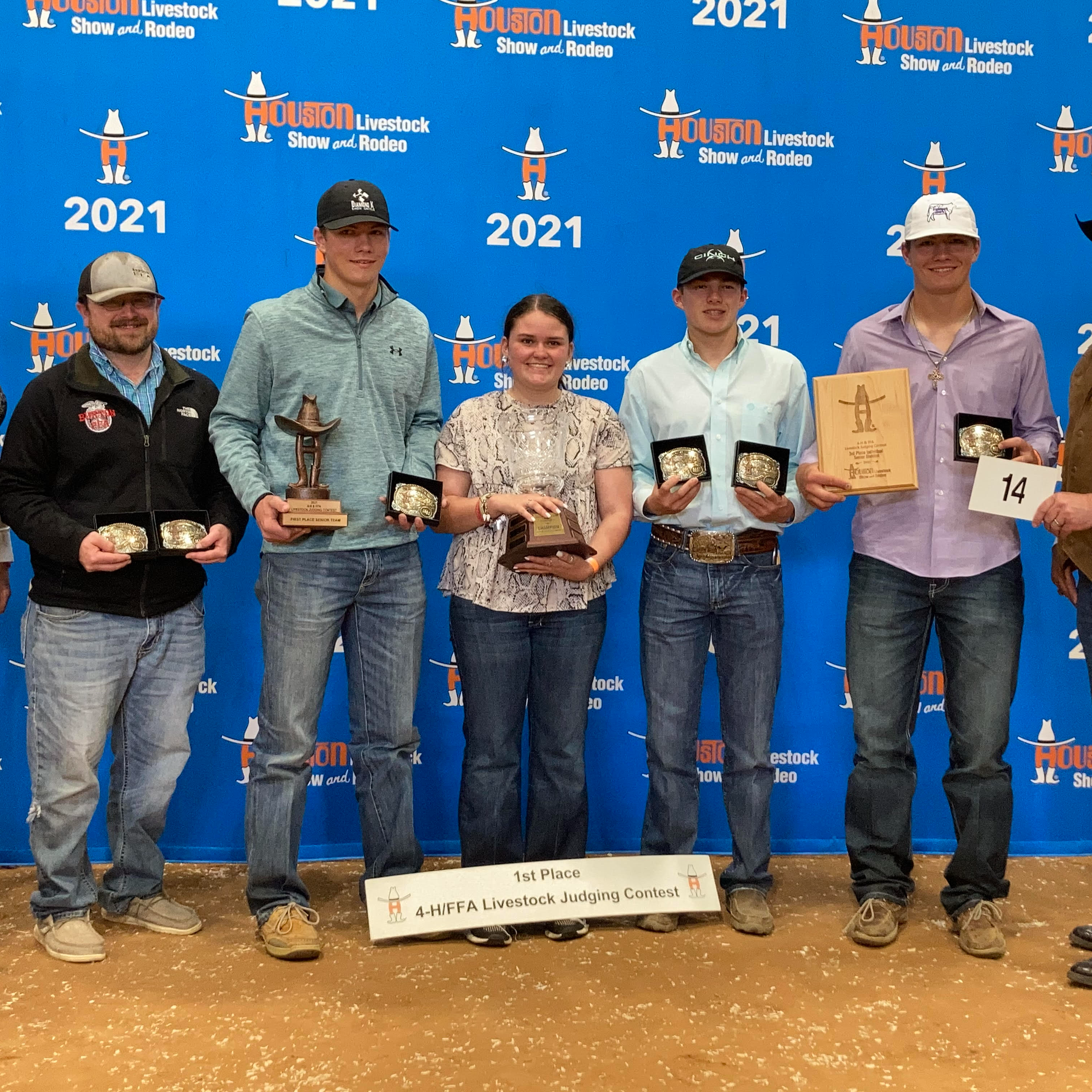 FFA students hold their trophies/belt buckles they have won
