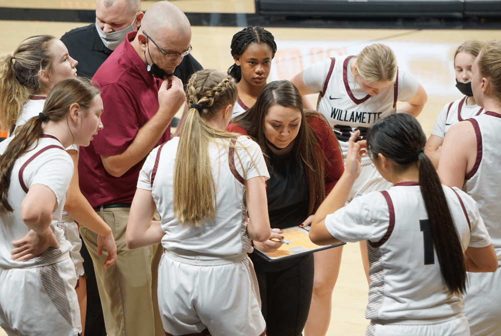 Danielle Bellando stands with WHS girls basketball members on a basketball court