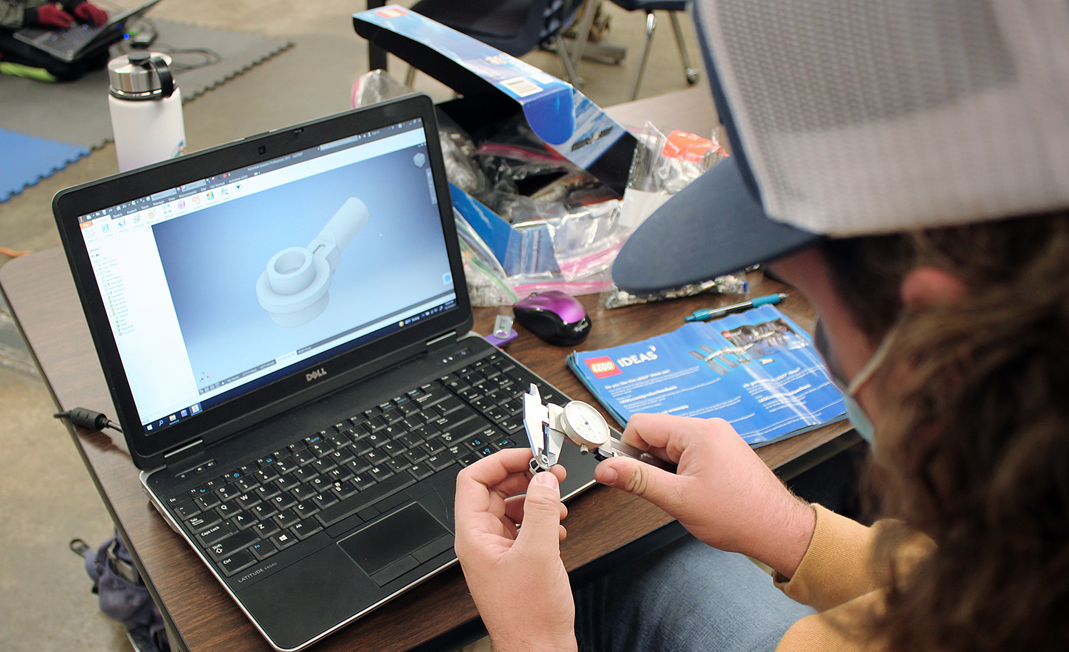  student measuring an object for his 3D design