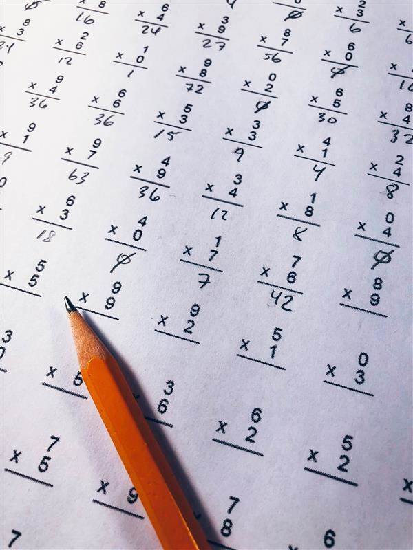 multiplication quiz with pencil on top