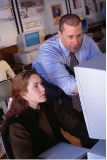 Teacher helping student on computer