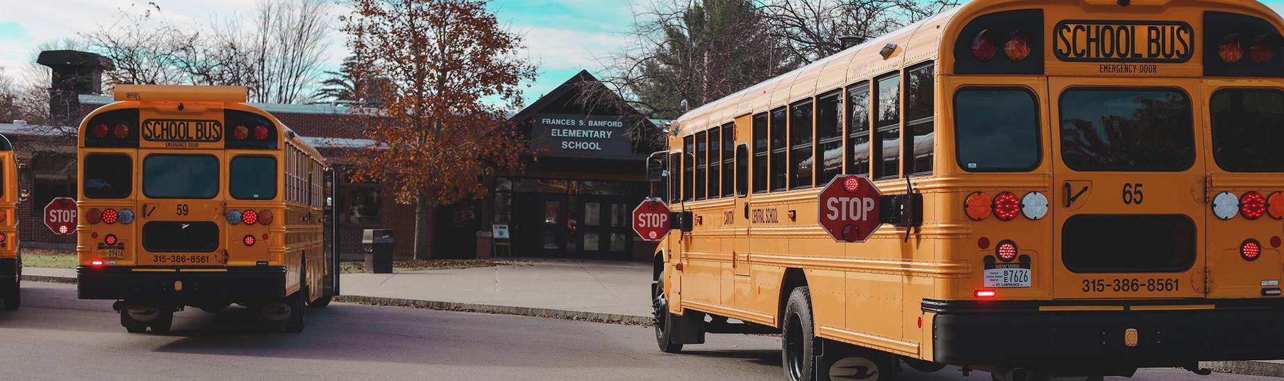 school buses lined up in front of school building