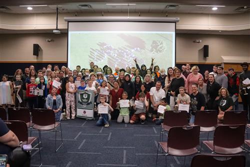  Students and staff pose with the Green Shield School banner