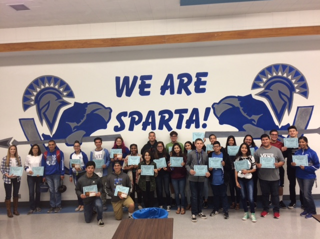 students holding up awards in the cafeteria