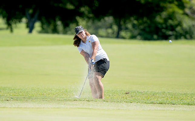 girls golfer takes a swing