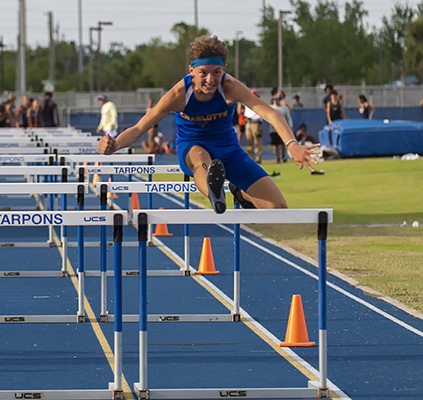 athlete running hurdles