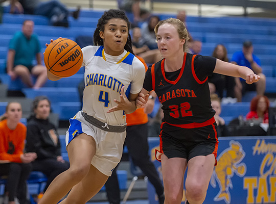 girls basketball dribbling around opponent