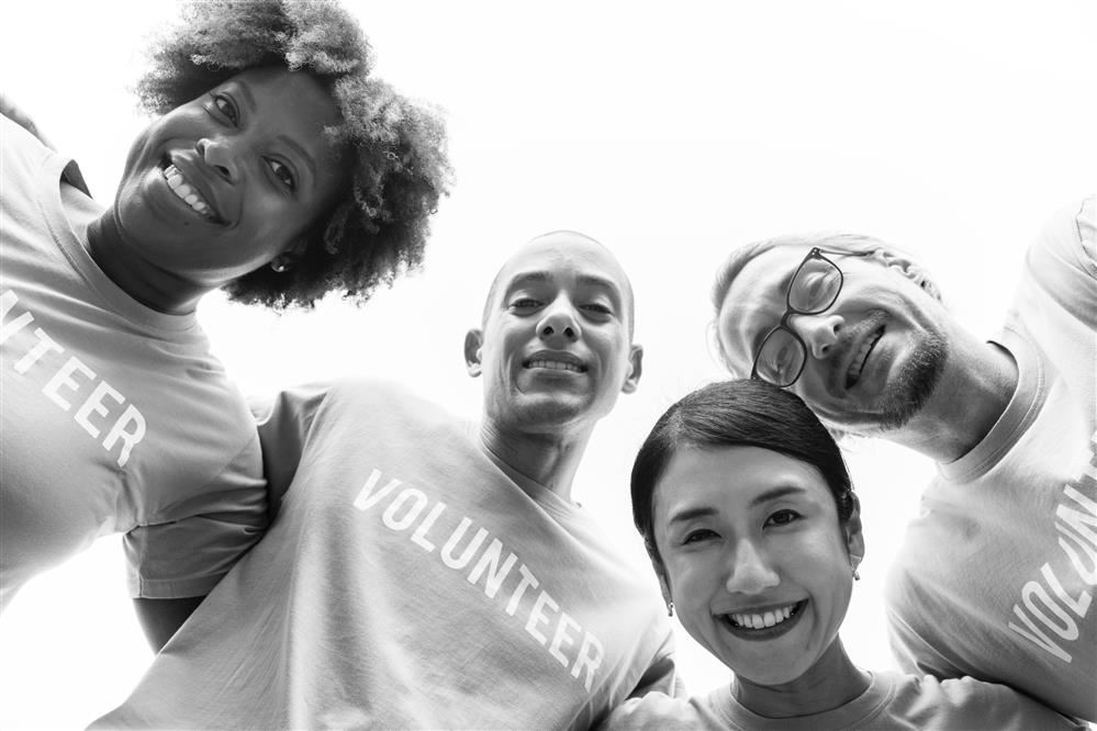 four adults with volunteer shirts 