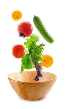 Fruit and Vegetables falling into a bowl. 