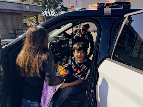 Male student sitting in the front seat of a Chino PD cruiser.