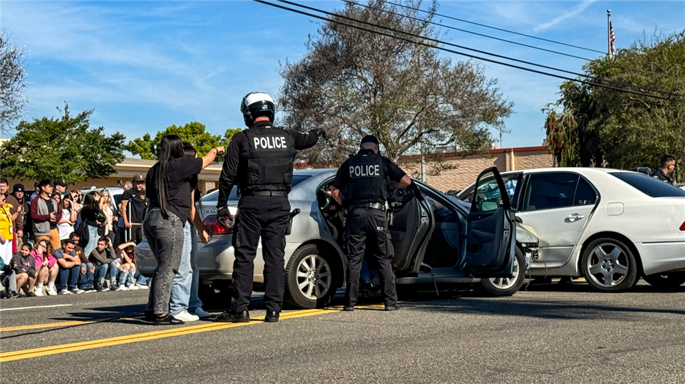  A police officer speaking with Don Lugo students during a staged traffic collision 