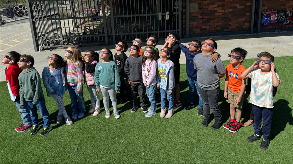  Students looking up at the sky to observe the solar eclipse