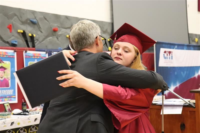  Exceptional Education graduate hugs educator.