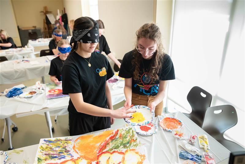  Students paint a photo blindfolded during an OCAY League challenge