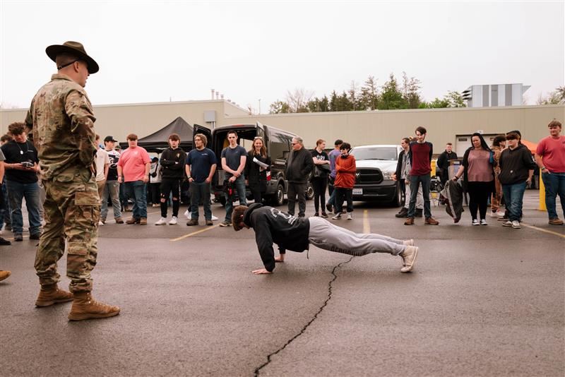 A student does push ups for a recruiter during the Armed Forces and Public Safety Expo