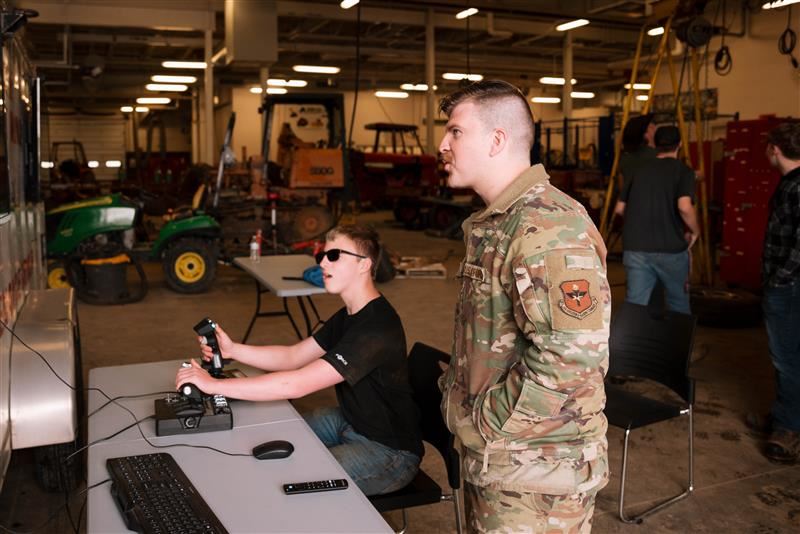 A student tries a flight simulator during the Armed Forces and Public Safety Expo