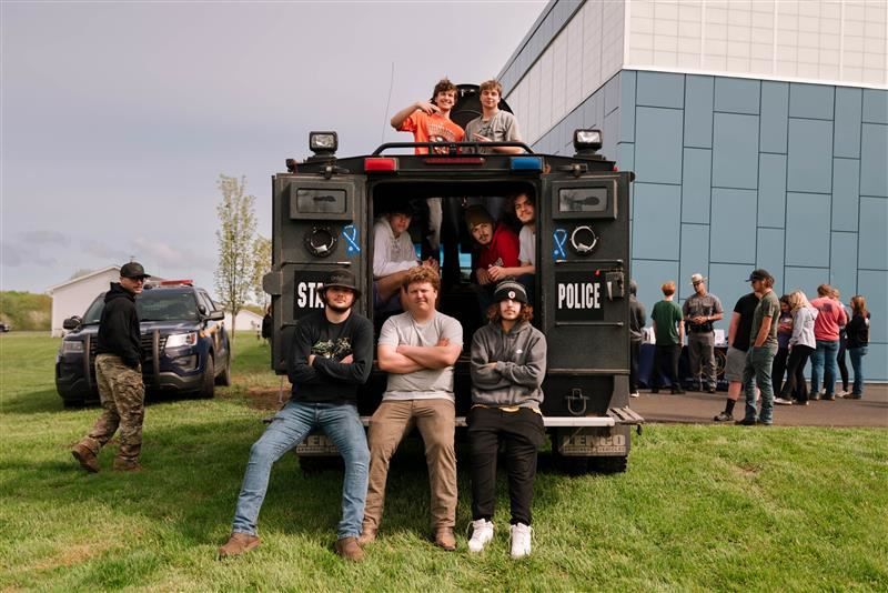A group of students sitting in a tank during the Armed Forces and Public Safety Expo