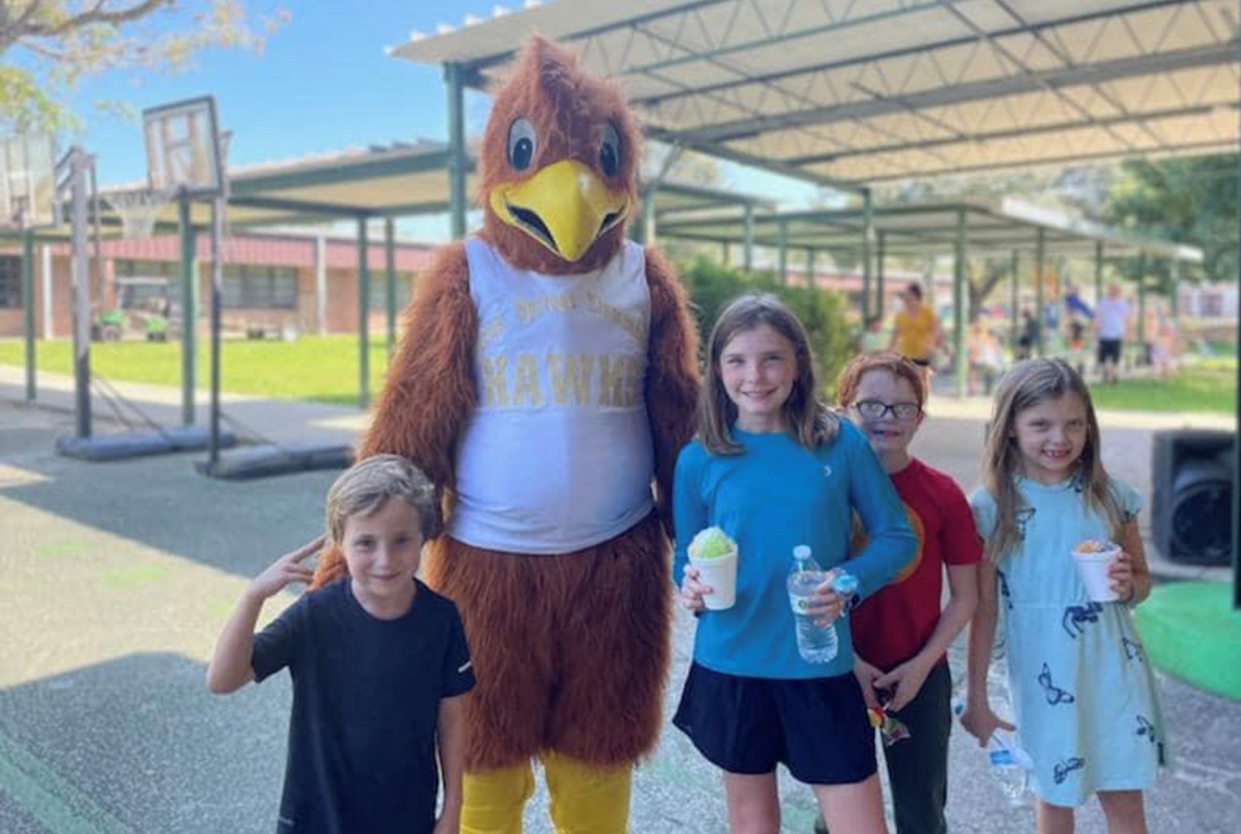 students standing next to mascot