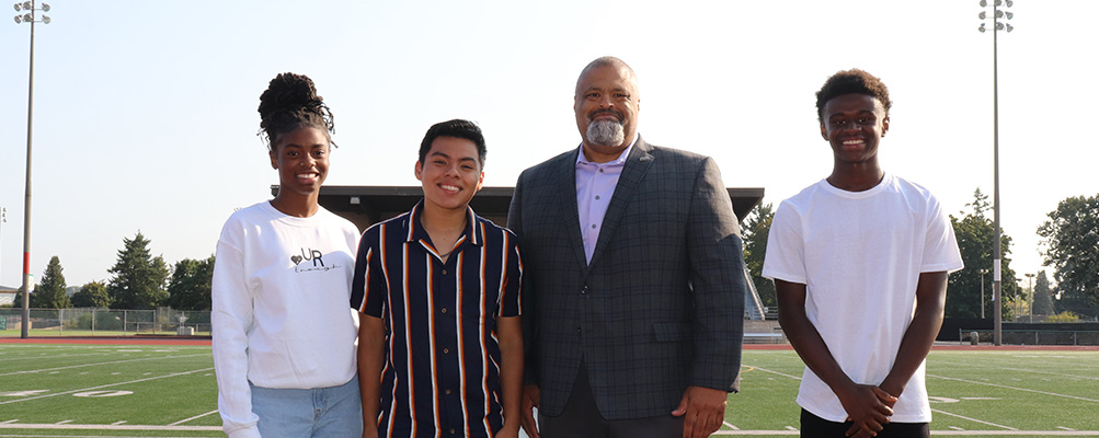 Superintendent Banner posing with secondary students