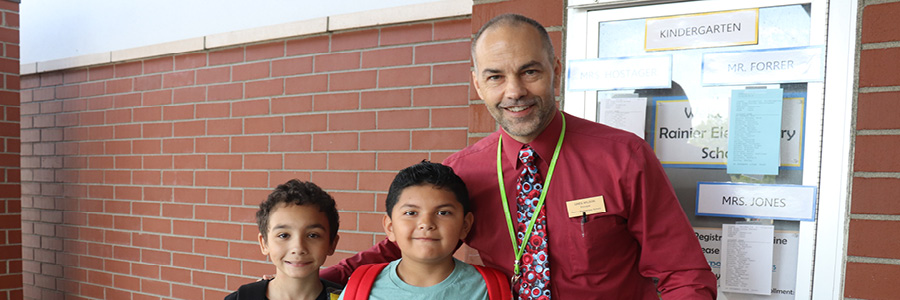 Photo of principal and students smiling together