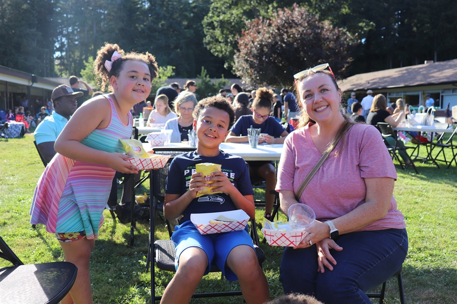 Mother, daughter and son smiling for photo while holding food boats