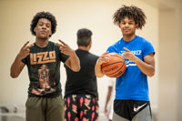 Late Nite Ofrece Refugio Después de Clases para Estudiantes: Dos estudiantes sostienen un balón de baloncesto y hacen gestos con las manos.