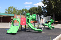 Proyectos de Verano y Planificación de Instalaciones Futuras: Un conjunto de juegos en el patio de una escuela con toboganes y túneles.