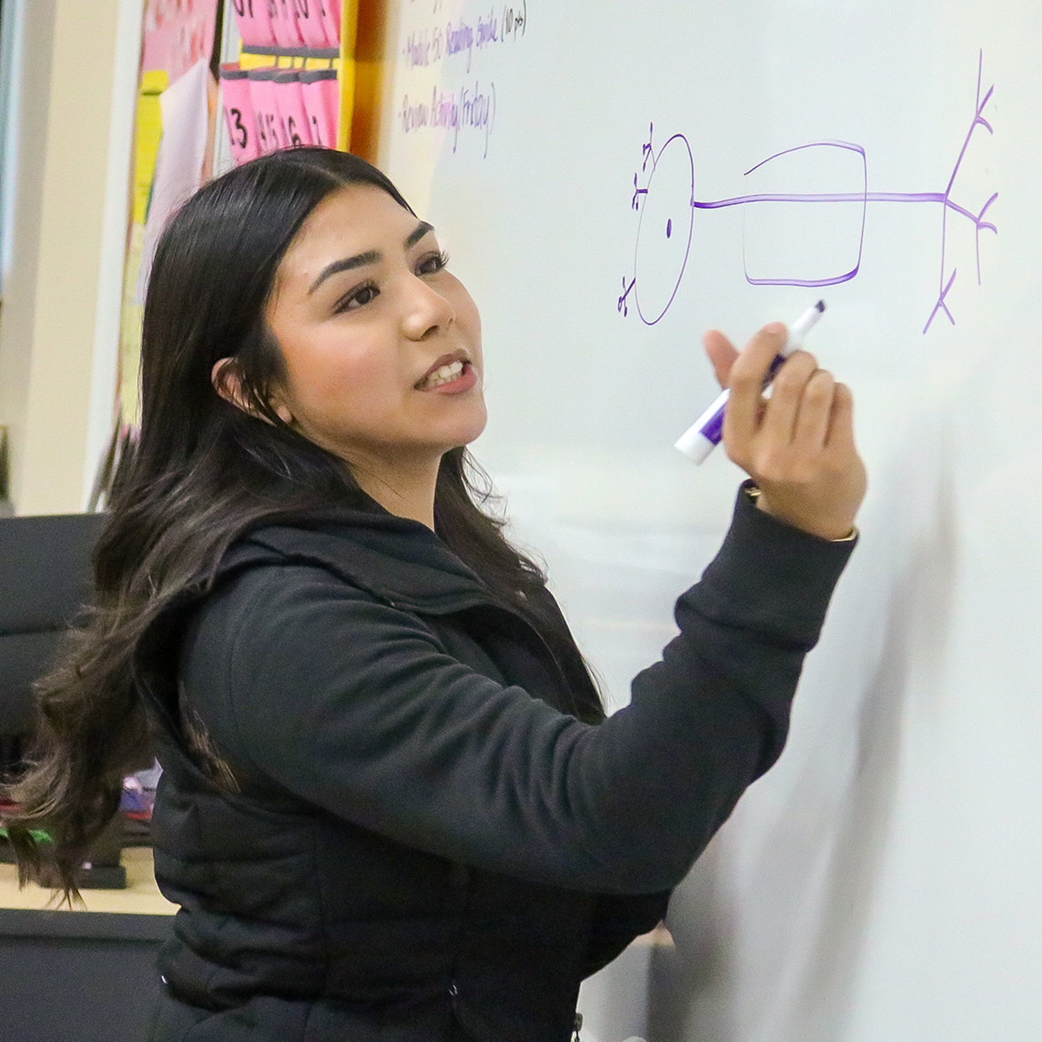 High school student writing notes on a whiteboard