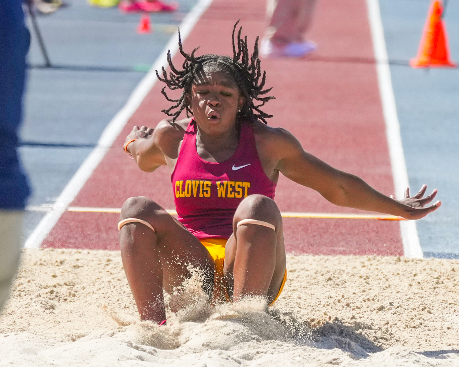 Clovis West High field athlete doing long jump