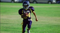 Image of a FW football player running on the field.