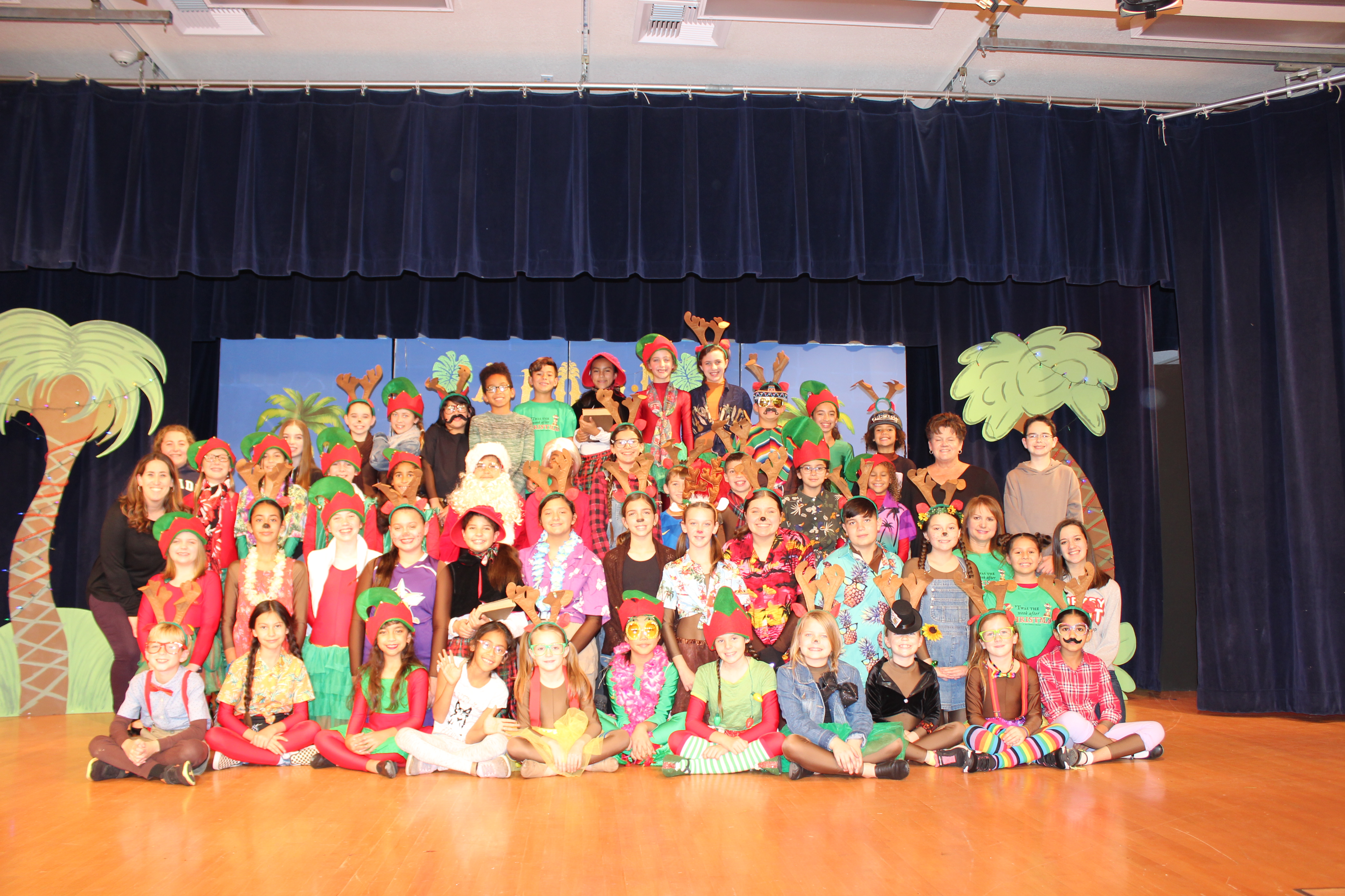 Gettysburg Children and Teachers dressed in Christmas attire sitting on the cafeteria stage